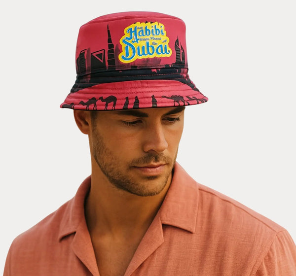 A man wearing a Habibi Dubai Bucket Hat (Pink) showcasing trendy streetwear style.